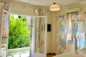 - une chambre avec une porte coulissante en verre donnant sur un balcon dans l'établissement Glyfada Path of Poets, à Athènes
