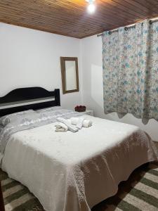 um quarto com uma cama com duas toalhas em Casa da Elena em Campos do Jordão