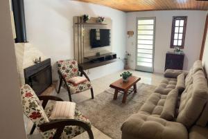 uma sala de estar com um sofá e uma lareira em Casa da Elena em Campos do Jordão