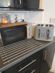 a kitchen with a microwave and a toaster oven on a counter at Flat 4 Corner House in Doncaster