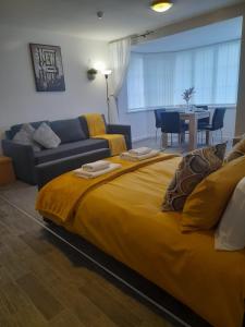 Un dormitorio con una gran cama amarilla y un sofá en Flat 4 Corner House, en Doncaster