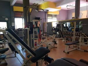 a gym with rows of treadmills and mirrors at Mondeus Inn Luxury 