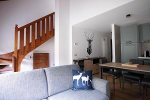 ein Wohnzimmer mit einem Sofa und einem Tisch in der Unterkunft IL CERVO - Dolomiti Affitti in Cavalese