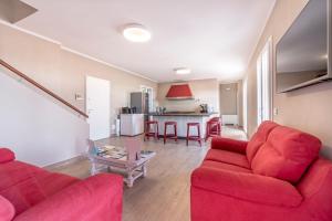 salon z 2 czerwonymi kanapami i stołem w obiekcie Agriturismo Cascina Trevo w mieście Spotorno