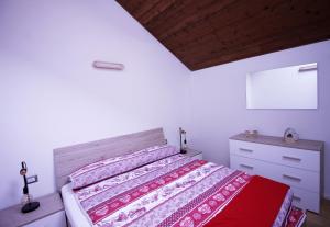a bedroom with a bed and a dresser at IL CERVO - Cavalese Olimpiadi 2026, Dolomiti Affitti in Cavalese