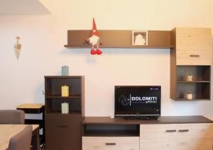 Habitación con escritorio y TV en la pared. en IL CERVO - Dolomiti Affitti en Cavalese