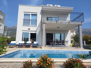 a house with a swimming pool in front of a house at Villa Fidelissima in Kaštela