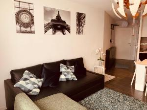 a living room with a couch and a clock on the wall at Superbe appartement neuf T3 de 71m2 en résidence a Marseille in Marseille
