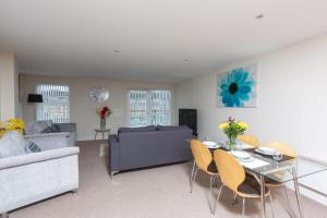a living room with a table and chairs and a couch at Marina View Apartment in Swansea
