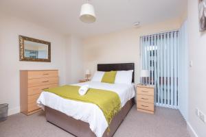 a bedroom with a large bed and a mirror at Marina View Apartment in Swansea