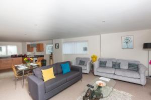 a living room with two couches and a table at Marina View Apartment in Swansea