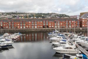 a bunch of boats docked in a marina with buildings at Marina View Apartment in Swansea