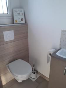 Łazienka z białą toaletą i umywalką w obiekcie Les coquetières w mieście Roz-sur-Couesnon