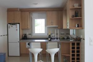 a kitchen with wooden cabinets and white appliances at Chalet privado, con vistas al mar. in Perelló