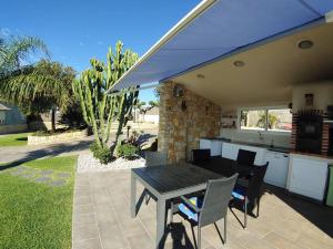 a patio with a table with chairs and an umbrella at Chalet privado, con vistas al mar. in Perelló