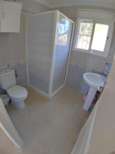 a bathroom with a toilet and a sink at Chalet privado, con vistas al mar. in Perelló