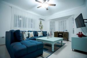 Paraíso的住宿－Villa impecable con piscina privada en Juan Dolio，客厅配有蓝色的沙发和桌子