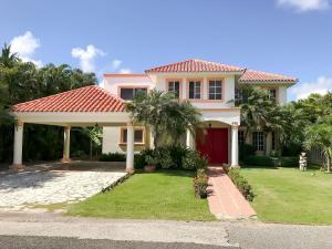 une maison avec un toit rouge et des palmiers dans l'établissement Villa impecable con piscina privada en Juan Dolio, à Paraíso