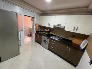 - une cuisine avec des placards blancs et un lave-linge/sèche-linge dans l'établissement Marchica bay 20 holiday apartment, à Nador