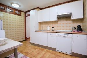 a kitchen with white cabinets and a sink at La casita del puerto in Agaete +13 photos