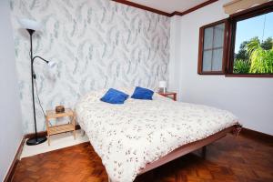 a bedroom with a bed with blue pillows on it at La casita del puerto in Agaete
