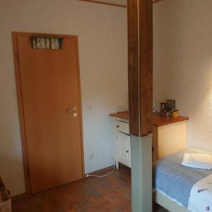 a room with a bed and a wooden door and a bedroom at De Cyprian Bed & Breakfast in Baaiduinen