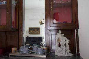 a group of tea cups and a clock on a table at Lux Domus Apartment in Bari