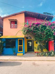 um edifício colorido com flores em frente em SAMO Hostel em Pipa