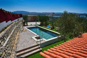 a swimming pool in a yard next to a stone wall at Villa Serenity in Šibenik