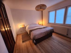 een slaapkamer met een bed met twee verlichting bij Toffe woning dichtbij zee, bos en natuur in De Panne