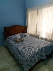 Un dormitorio azul con una cama con zapatos. en Casa a sólo 5 minutos de Paso Canoas en La Cuesta