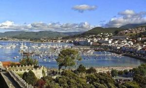 a harbor with boats in the water and a city at centro de vigo con parking gratis in Vigo