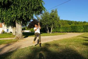a man jumping in the air while holding a kite at Gîte des Basses Rivières in Huismes