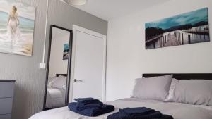 ein Schlafzimmer mit einem Bett mit blauen Handtüchern darauf in der Unterkunft Cheerful 3 Bedroom Apartment in Nottingham