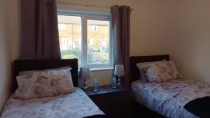 een slaapkamer met 2 bedden naast een raam bij Cheerful 3 Bedroom Apartment in Nottingham