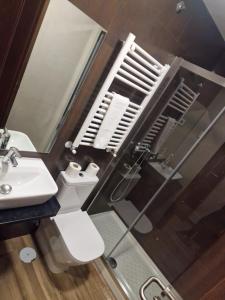 y baño con lavabo, aseo y espejo. en Hostal Corazón de Madrid, en Madrid