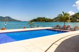 a swimming pool with a view of the water at Requinte à beira mar! Recarregue suas energias! in Angra dos Reis