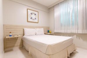 a bedroom with a large white bed and a window at Requinte à beira mar! Recarregue suas energias! in Angra dos Reis