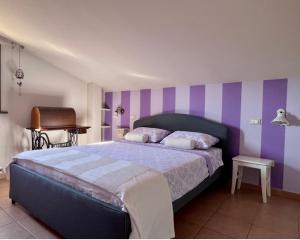 a bedroom with a bed with purple and white stripes at Sweet home tuscany in Bientina