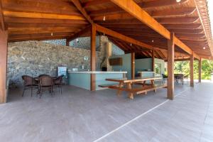 a patio with a table and chairs and a stone wall at Requinte à beira mar! Recarregue suas energias! in Angra dos Reis