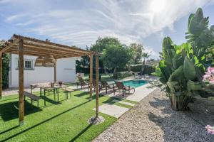 un patio trasero con piscina y pérgola de madera en Villa en Marbella Artola&Friends, en Marbella
