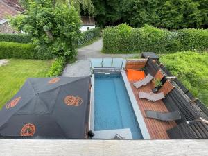einen Blick über einen Pool mit Sonnenschirm in der Unterkunft La Suite Diamant in Theux
