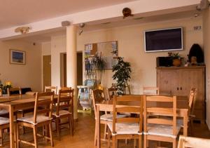 a dining room with a table and chairs and a tv at Pensjonat Kotwica in Kuźnica