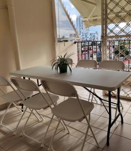 a table and chairs in a room with a balcony at Appt Morne la Loge in Pointe-à-Pitre