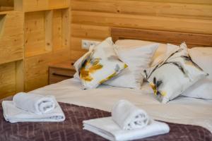 - un lit avec des serviettes et des oreillers dans l'établissement Willa POGOŃ ZD12, à Krynica-Zdrój
