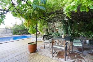 un patio con mesa y sillas junto a una piscina en La Posada del Gato, en Monachil