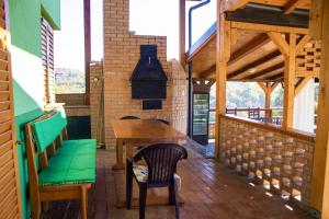 a porch with a wooden table and chairs and a fireplace at Holiday Home Green in Rakovica