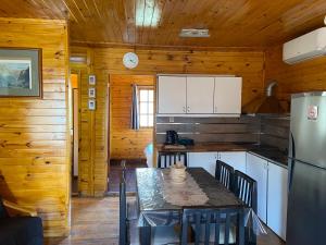 a kitchen with a table and a refrigerator at La Cabaña de Heidi in Concordia