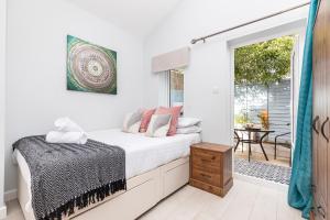 Schlafzimmer mit einem Bett und einer Tür zu einer Terrasse in der Unterkunft Stylish studio flat with private patio and free on-street parking in Bournemouth