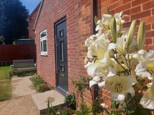 una casa di mattoni con una porta nera e fiori bianchi di Stylish studio flat with private patio and free on-street parking a Bournemouth
